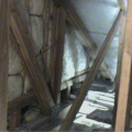 The floor cavities under this attic kneewall are completely open to the unconditioned attic space and a prime target for wind washing