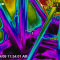Infrared imaging shows cold conditioned air pouring out of the open floor cavities under this attic kneewall into the hot unconditioned attic