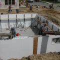Scaffolding is continually raised as courses of foam brick are added so that the pour man can see both sides of the wall during the pour.