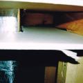 Cut-away view showing unsealed gaps around a heating duct that goes through a wall