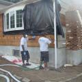 Siding has been removed so cellulose insulation can be dense-packed into the exterior walls of this home