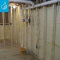 Right - Closed-cell spray foam covers the interior of the foundation wall and wall framing is placed to the inside of the spray foam.