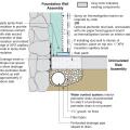 Spray foam extends down the inside of the foundation wall to the uninsulated slab; because the wall lacked exterior perimeter drainage, the slab was cut and an interior footing drain was installed.