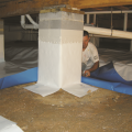 Right - After wrapping the posts, a technician lays a vapor retarder over the floor of a crawlspace. 