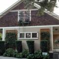 Vines growing on vertical trellises, along with tall shrubs, provide very effective shade for the east side of this house.