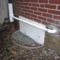Before sealing and insulating the crawlspace, the windows were sealed, the window wells backfilled, and sumps pumps were installed that discharged to the gutter downspouts