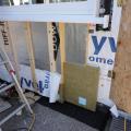 Vapor-permeable mineral wool insulation is installed on the exterior side of the sill beam during an exterior wall retrofit to allow the sill beam to dry to the outside