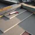 Polyisocyanurate rigid foam insulation is installed in multiple layers with staggered, taped seams over the flat roof