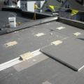 The wood blocking for future PV panel installation extends above the surface of the top layer of polyisocyanurate rigid foam insulation installed as part of a flat roof retrofit