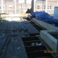 The existing sheathing boards are removed near the perimeter of the flat roof and pressure-treated plywood is installed at the vertical face of the parapet