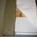Flashing covers the bottom edge of this wall sheathing then housewrap is layered over the top edge of the flashing.