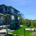 These wildfire-resistant decks have a solid decking surface, metal railings, and the underside timber supports are covered with flame-resistant fiber cement board; also the decking is set back from the vegetated slope. 