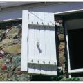 This windows in this very old building in the Virgin Islands are protected from hurricanes with robust shutters constructed of 2x4 lumber, bolted connections, and heavy metal hinges. 