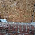Wrong - Through-wall flashing has not been installed at brick wall intervals and house wrap is missing.