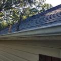 Wrong - Trees are overhanging and touching the roof and debris has collected in the gutters.