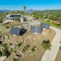 Renewable resources on this self-sufficient home include 22 kW of sun-tracking photovoltaic panels, a 3.2-kW wind mill, batteries for power storage, a solar thermal water heating system, and nine 10,000-gallon water tanks. 