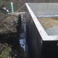 A dimpled rain mat and perforated drain pipe provide drainage around the basement foundation.