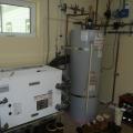 The very high efficiency (4.7 COP) ground-source heat pump provides hot water to a tank for radiant floor heat and domestic hot water.