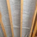 Spray foam insulation air-seals and insulates the floor above the garage; the joist will be filled with fibrous insulation in this flash-and-batt approach.