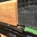 The metal screening keeps insects out of the black mesh plastic fabric which provides a ventilation gap behind the home’s siding, which includes the ship-lapped cypress shown here.