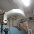 In this traditional steam header, the steam makes a 90-degree turn to supply the building, while the heavier water droplets are carried back to the boiler