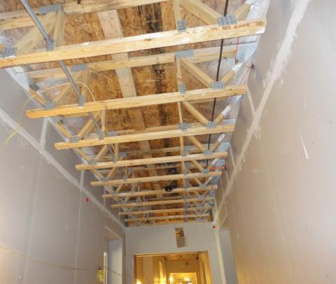 This air-sealing approach uses the wall drywall to isolate the corridor from the individual units in a multifamily building that has a truss floor structural system