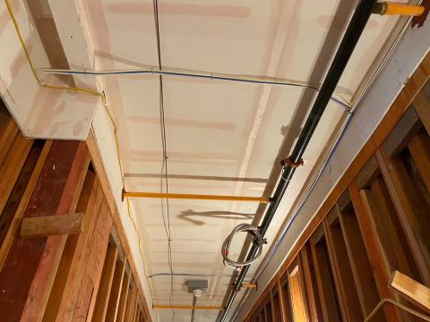 The ceiling and sides of this service corridor in a multifamily building are air-sealed with mudded and taped drywall prior to installing pipes, wiring, and ducts.