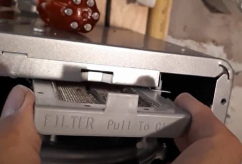In some tankless water heater models, the air filter is clearly labeled; this reusable filter slides out of its slot for easy cleaning.