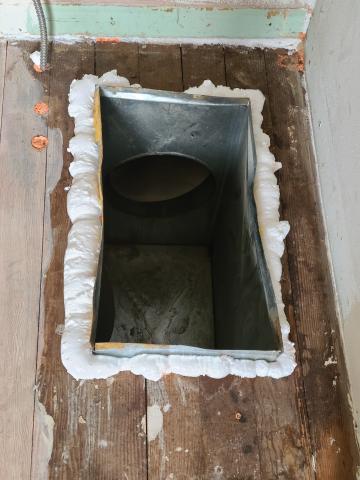 The gaps around this HVAC boot have been air sealed with spray foam to limit air leakage between the conditioned space and the basement or crawlspace.