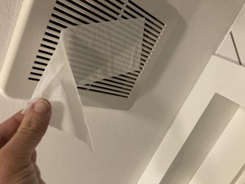 To test bathroom exhaust fan airflow, hold a tissue up to the fan while it is running; if it holds, airflow is good.