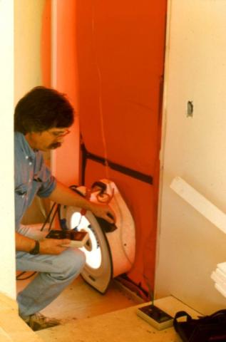 A blower door is used to test air leakage in this multifamily building during construction 