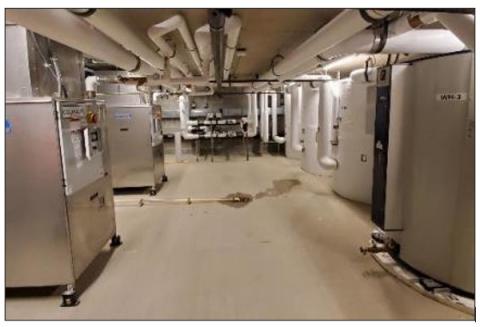 This mechanical room contains both the storage tanks (right) and heat pumps (left) of a central heat pump water heating system
