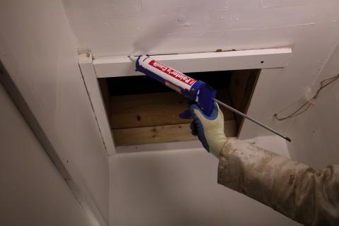 Caulk around the trim of the attic access panel or door to improve the air sealing between the living space and the attic.