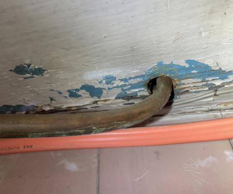 The gaps in the subfloor around this copper piping should be sealed with caulk or canned spray foam.