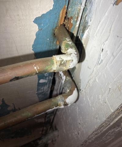 The gaps in the subfloor around these copper plumbing pipes should be caulked to protect the conditioned space from air infiltration 