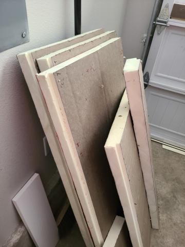 Pieces of rigid foam insulation are cut to size to be fitted into the garage door.