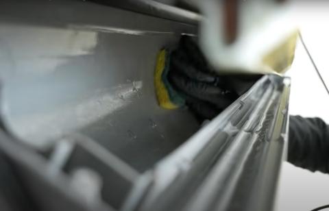 An HVAC contractor is deep cleaning the surfaces inside a minisplit heat pump that can only be reached when the blower wheel is removed
