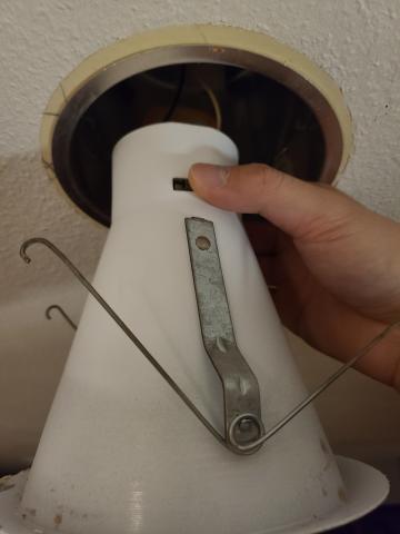 To remove an old can light from its housing, squeeze the two metal spring clips located on each side of the can to disconnect it from the permanent housing 