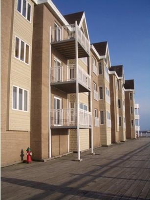 These balconies on a multistory multifamily building use “clip-on” connections to attach to the exterior walls with minimal thermal bridging; external poles carry most of the structural load 