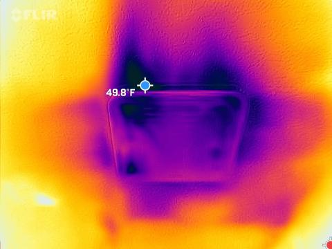 The dark spots and streaks on this infrared camera photo clearly show cold air leaking in through gaps around a bathroom exhaust fan