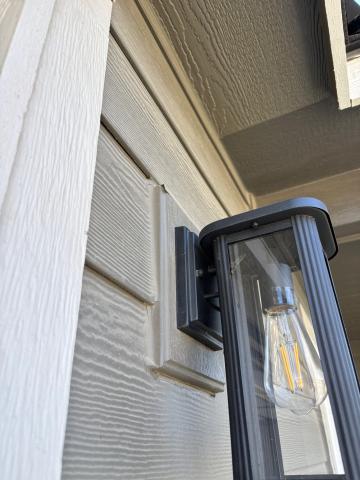 This porch light has cap flashing to direct water out and over the wood trim; the drip edge on the metal flashing could protrude out further.