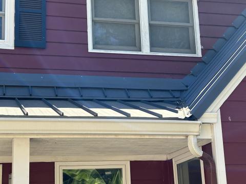 The metal flashing used at this wall-to-roof transition is incorrectly layered over, not under, the siding, and is nailed into the siding, creating holes where water can infiltrate the wall 