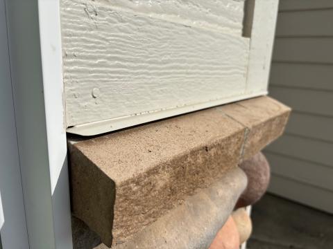This through-the-wall flashing directs any water that get into the wall through the lap siding out at the transition to the stone cladding which has a capstone that is properly sloped away from the wall.