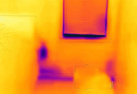 This IR camera image shows a cold spot (in purple) at an electrical outlet on an exterior wall due to lack of insulation; some streaking is also visible and indicates air leakage.