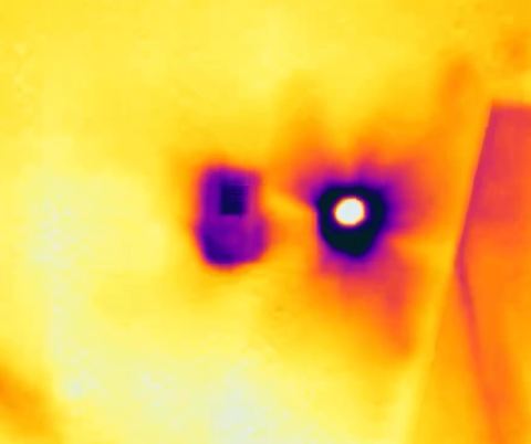 The very dark area around the recessed light fixture indicates significant heat loss while the purple streaks radiating out indicate air leakage; the purple area around the heating register to the left indicates heat loss likely due to missing insulation