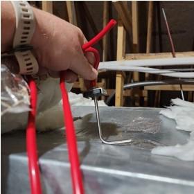 The manometer hose for a duct leakage test is connected to a static pressure probe which will be inserted into a duct with the tip pointing into the oncoming air stream