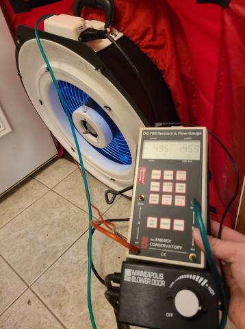 The hoses on this manometer are correctly connected with the red hose connected for the house with reference to outside and the green hose connected for the fan with reference to the house for a blower door test to show air leakage by pressure differences when the house is depressurized to about 50 Pascals.