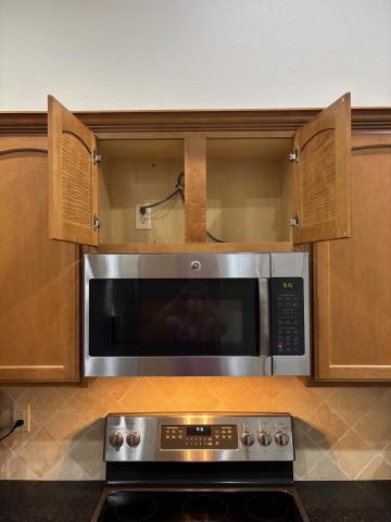 There is no duct visible in the cabinet above this microwave oven.