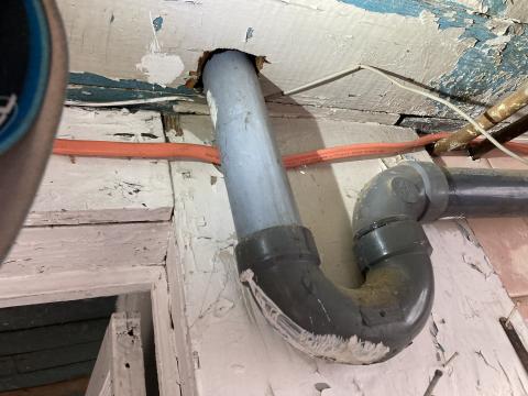 The large hole in the subfloor for this sink drain is a source of air leakage and should be sealed using canned spray foam.