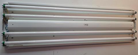 The cover has been removed from this linear light fixture, exposing the four fluorescent tubes; the metal housing and the ballast underneath it should be removed if replacing the fluorescent tubes with Type B or C LEDs 